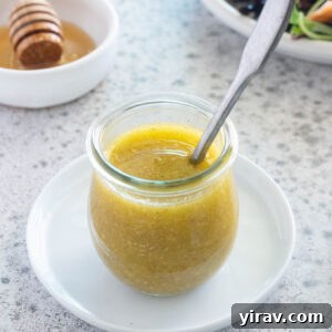 Honey mustard dressing in jar with a spoon