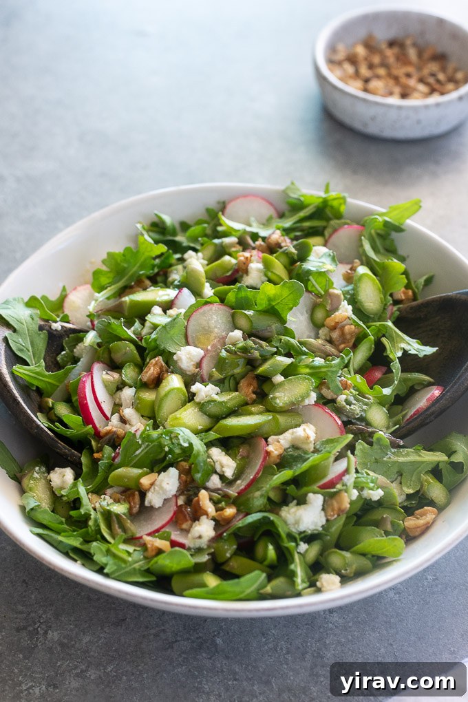 Cold asparagus salad tossed in a white bowl ready to be served