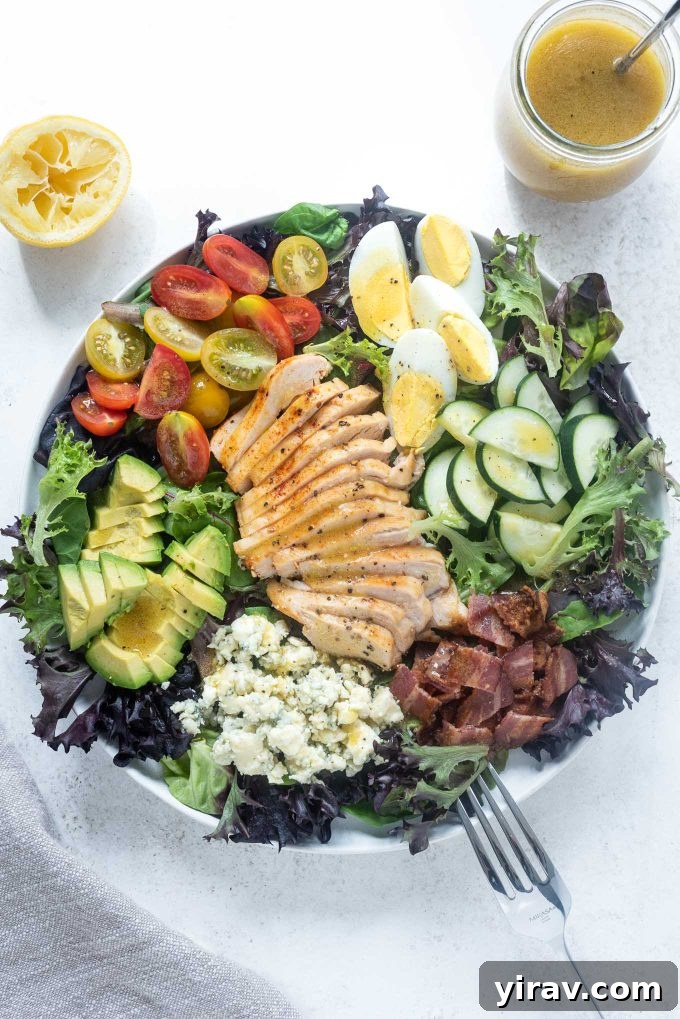 Generous Chicken Cobb Salad in a large bowl, filled with juicy chicken breast, crisp bacon, blue cheese, and creamy avocado.