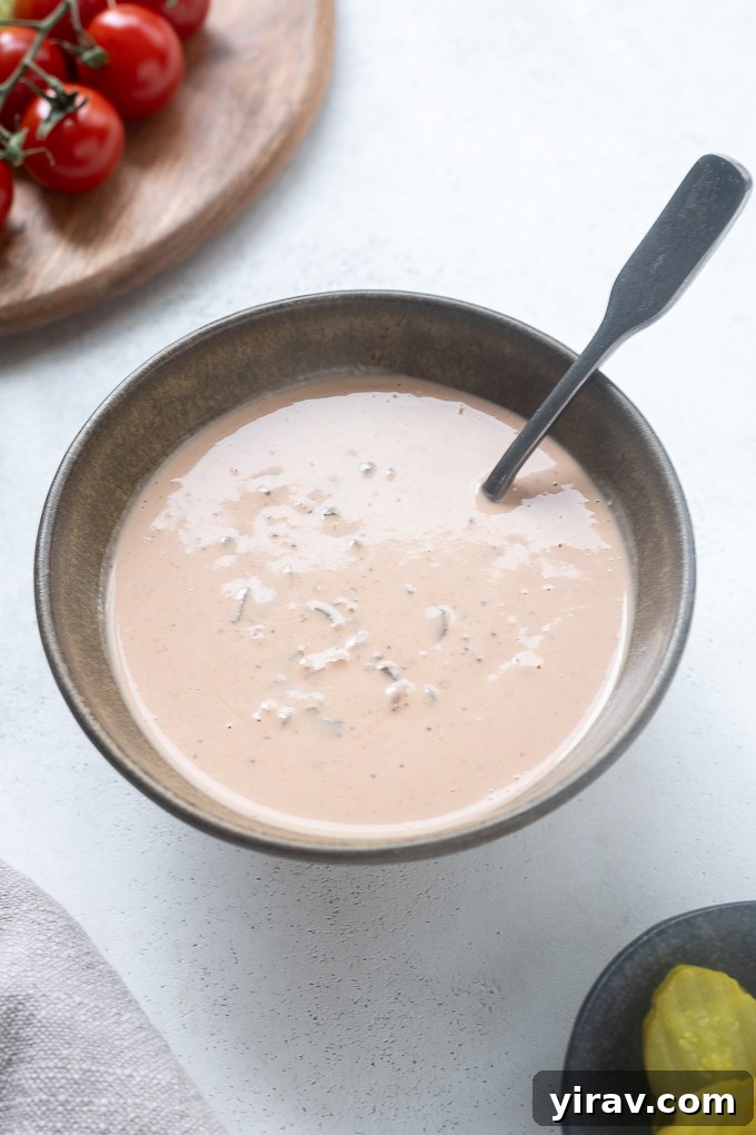 Bowl of burger sauce with condiments around it
