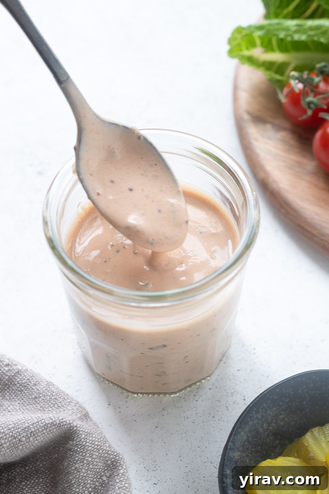 Burger sauce drizzling from a spoon