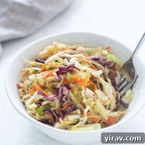 Vinegar coleslaw in a bowl with a fork digging in