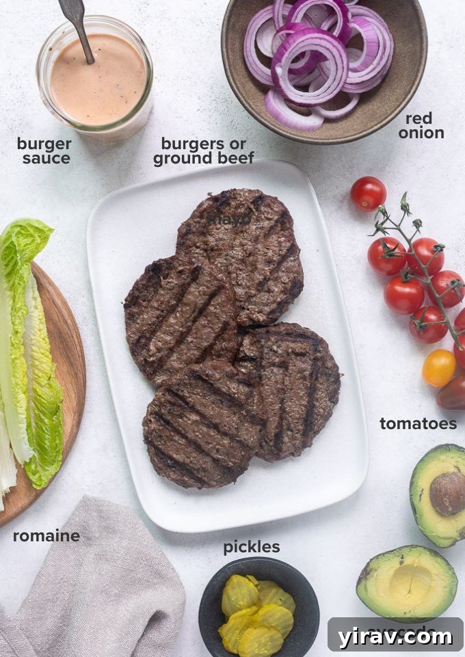 Bunless Burger Delights 4 An array of fresh ingredients laid out, including ground beef, romaine lettuce, cherry tomatoes, red onion, avocado, and dill pickle chips, ready for making burger bowls.