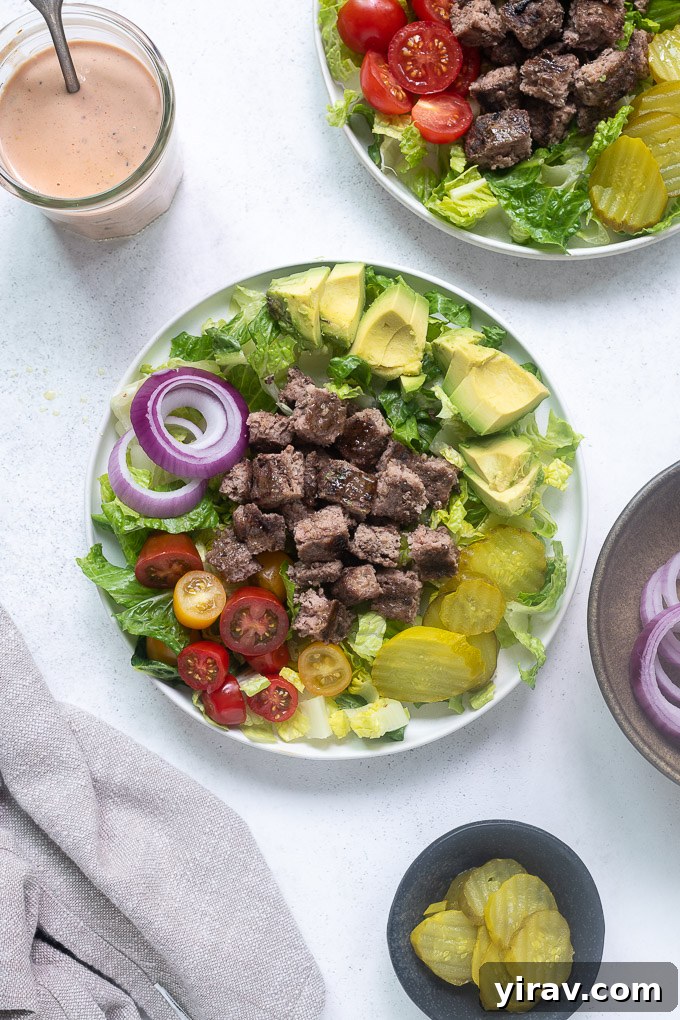 Bunless Burger Delights 5 Hands arranging a hamburger salad in a bowl, showing the layering of lettuce, a burger patty, and fresh toppings.