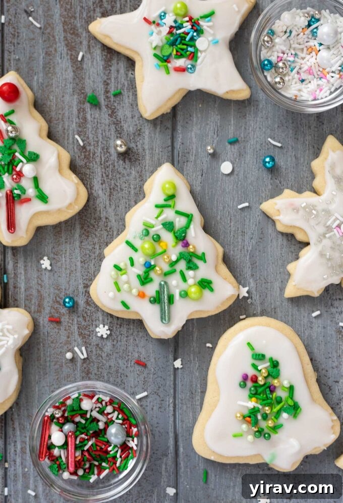 Beautifully decorated cut out Christmas cookies with vanilla icing and shiny festive sprinkles.