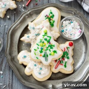 Christmas sugar cookies on a plate with sprinkles.