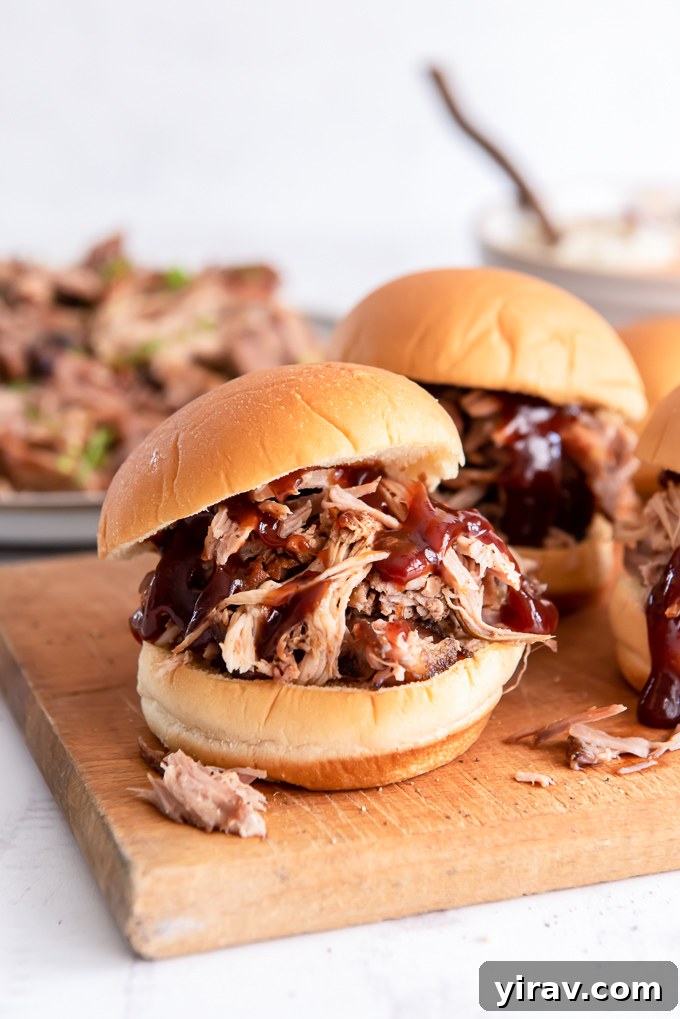 Pulled pork sandwich with barbecue sauce on a cutting board, ready to be served