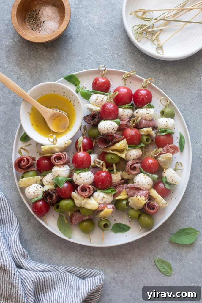 Antipasto Bites 2 Antipasto skewers on a platter with Italian dressing.