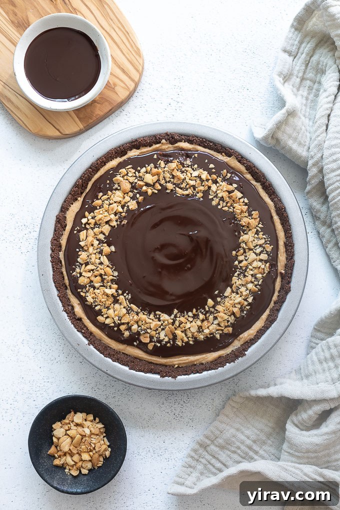 A whole Chocolate Peanut Butter Pie, richly topped with a smooth chocolate ganache and a sprinkle of chopped peanuts, ready to be sliced.