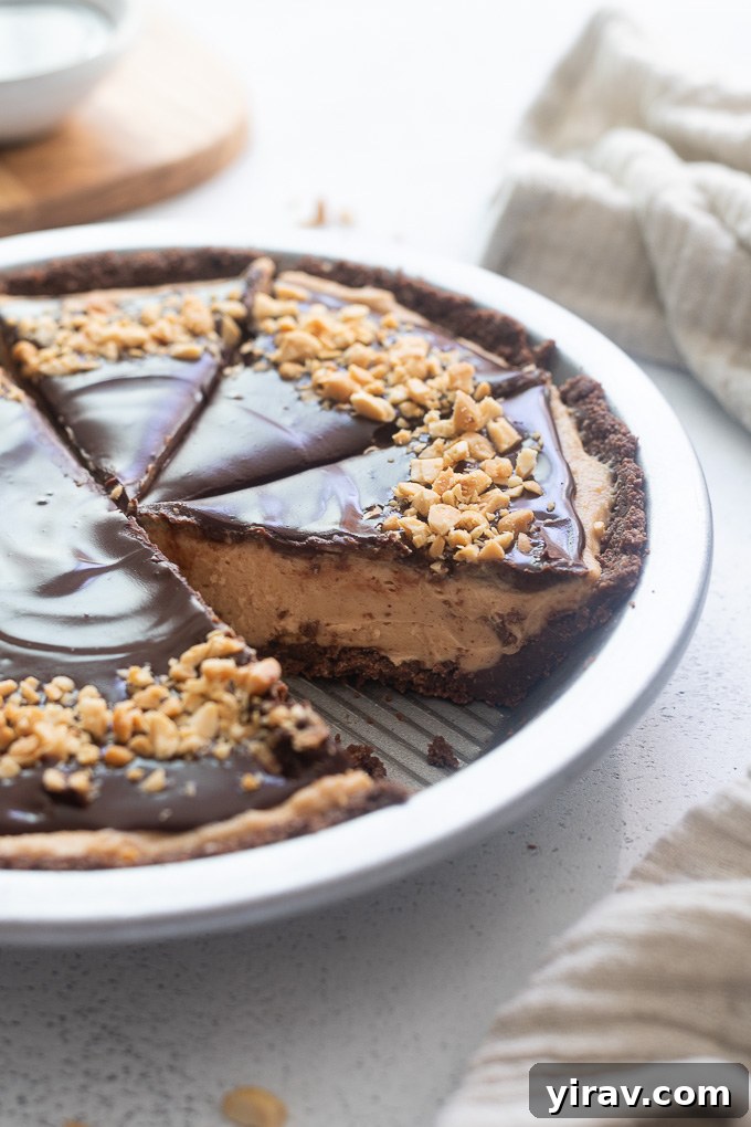 A slice of creamy peanut butter pie, still in the baking pan, showing the thick filling and chocolate crust.