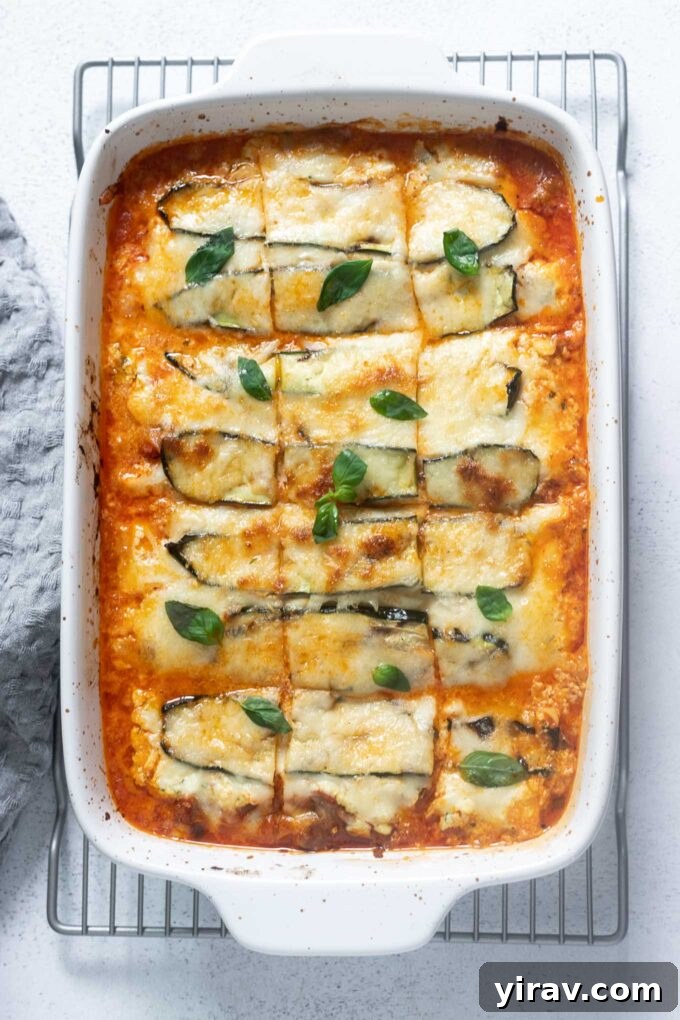 No-Noodle Zucchini Lasagna 2 Zucchini lasagna in a baking dish cut into squares, showcasing layers of zucchini, sausage, and cheese.