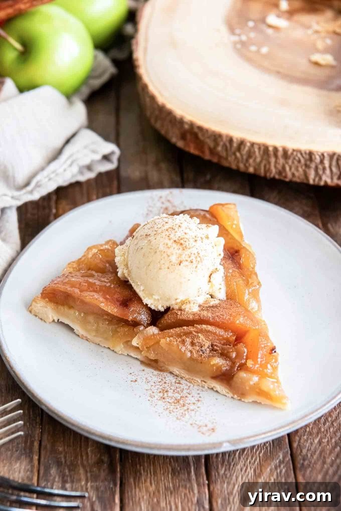 Slice of apple tarte tatin on a plate with ice cream