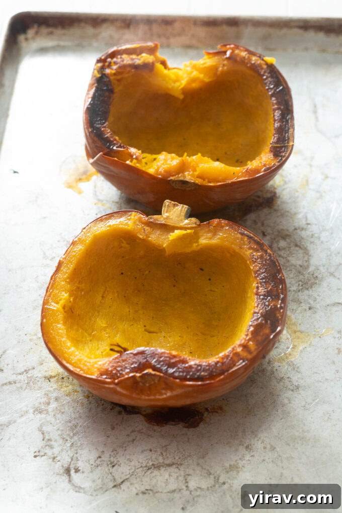 Whole roasted pumpkin on a baking sheet, golden brown and inviting.