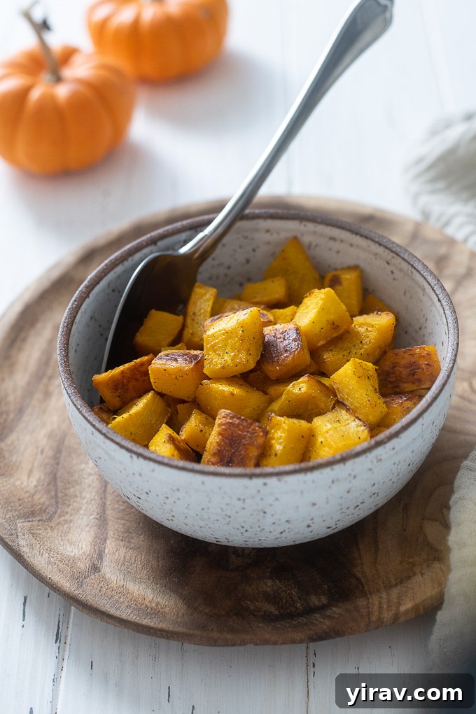 A bowl filled with golden-brown, perfectly roasted pumpkin cubes, ready to be enjoyed.