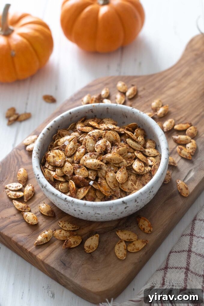 A bowl of perfectly roasted pumpkin seeds on a wooden cutting board, ready to be enjoyed as a healthy snack or salad topping.