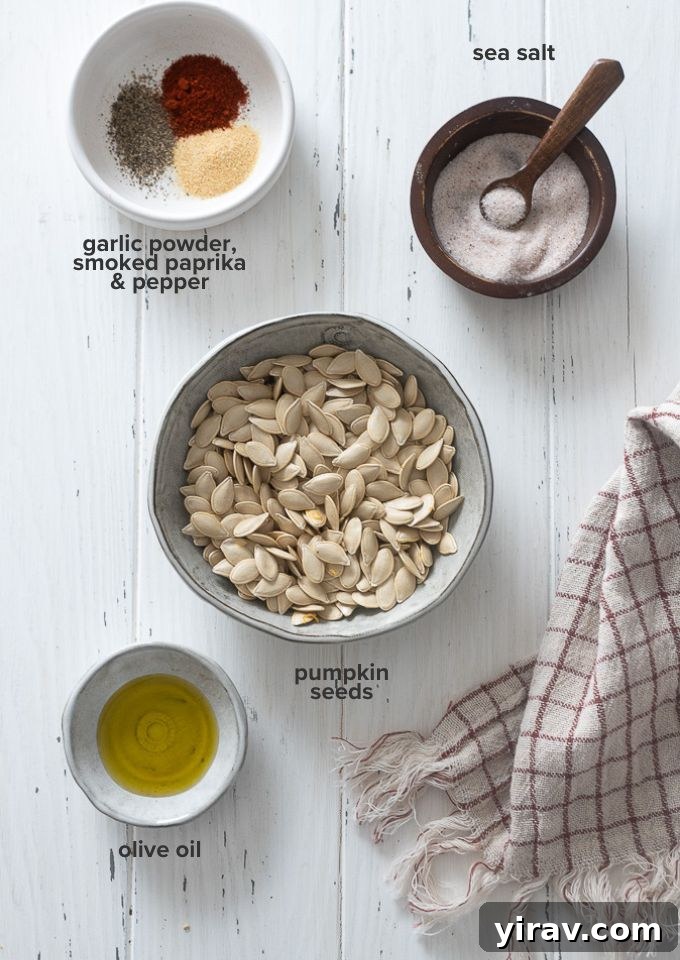Raw pumpkin seeds, olive oil, and a selection of spices laid out on a surface, highlighting the simple ingredients for roasted pumpkin seeds.