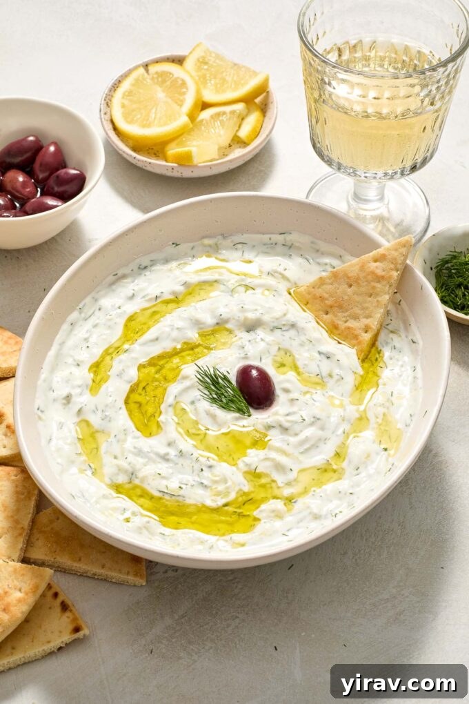 Easy Greek tzatziki in a bowl drizzled with olive oil.