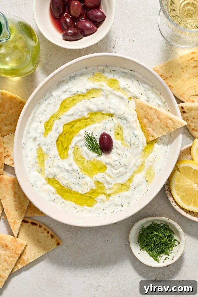 Greek tzatziki sauce topped with olive oil, dill and kalamata olive on top.