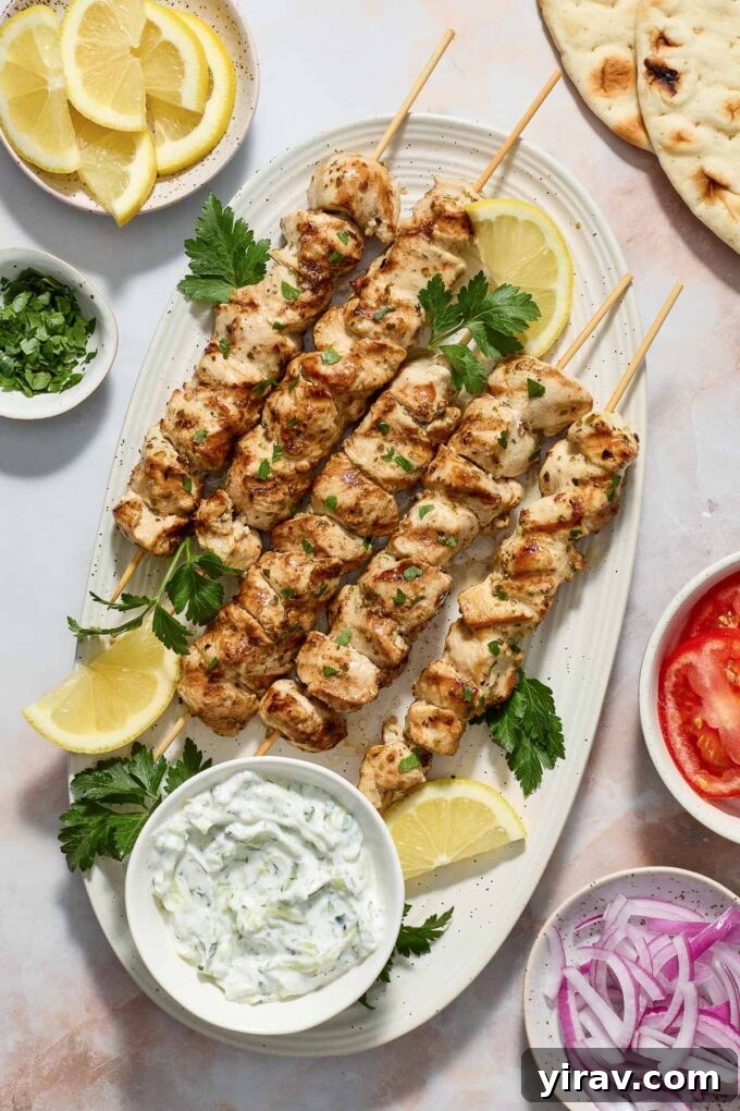 Platter of Greek Chicken Souvlaki with tzatziki sauce, fresh lemon, and oregano.