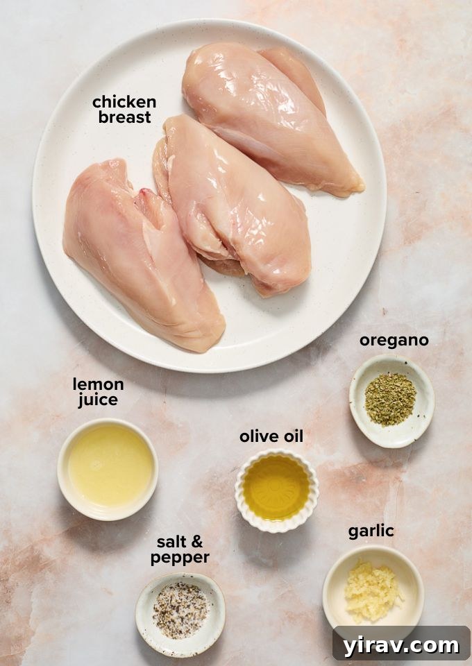 Ingredients laid out for Greek Souvlaki chicken recipe, including chicken, lemon, olive oil, garlic, and oregano.