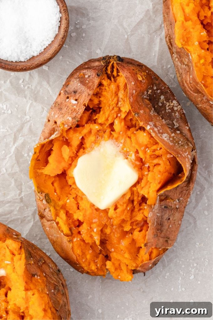 Baked sweet potato sliced open with a pat of butter melting inside