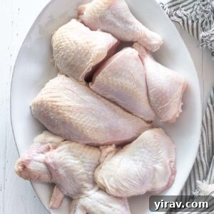 A whole chicken cut up on a platter, ready for cooking