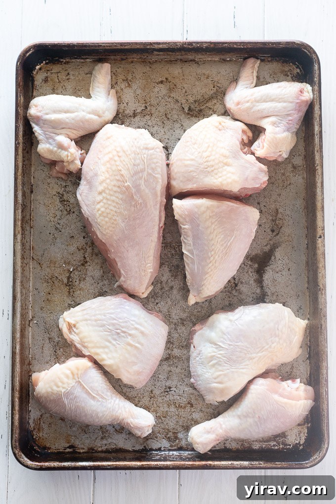 A whole chicken expertly cut into 8 uniform pieces, laid out for inspection, demonstrating the successful execution of the butchering technique.