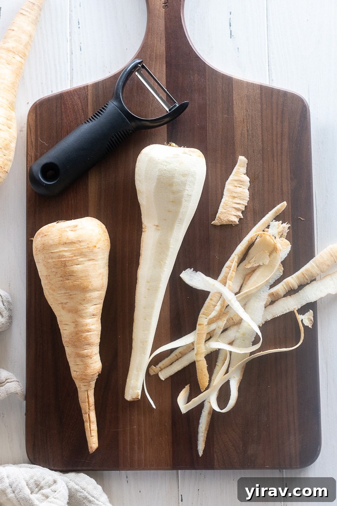 Peeled parsnips neatly arranged on a wooden cutting board, showcasing their creamy interior