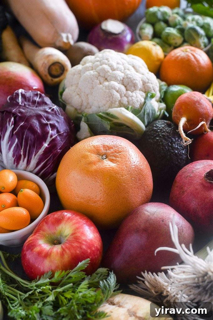 Array of winter vegetables and fruits including grapefruit, cauliflower, pomegranate, and fennel