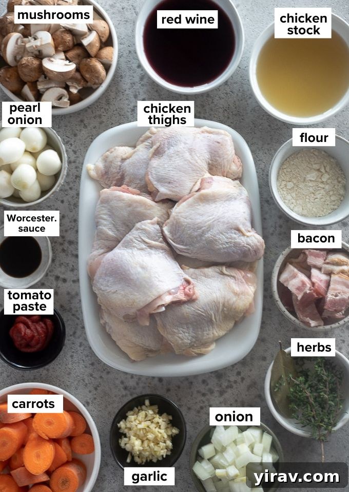 French Red Wine Chicken Stew 4 Various ingredients for Coq au Vin laid out on a wooden surface, including chicken, wine, bacon, and vegetables.