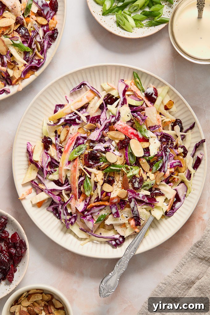 Bright Apple Fennel Slaw 8 A serving of Fennel and Apple Slaw on a white plate with a fork, emphasizing its appetizing presentation.