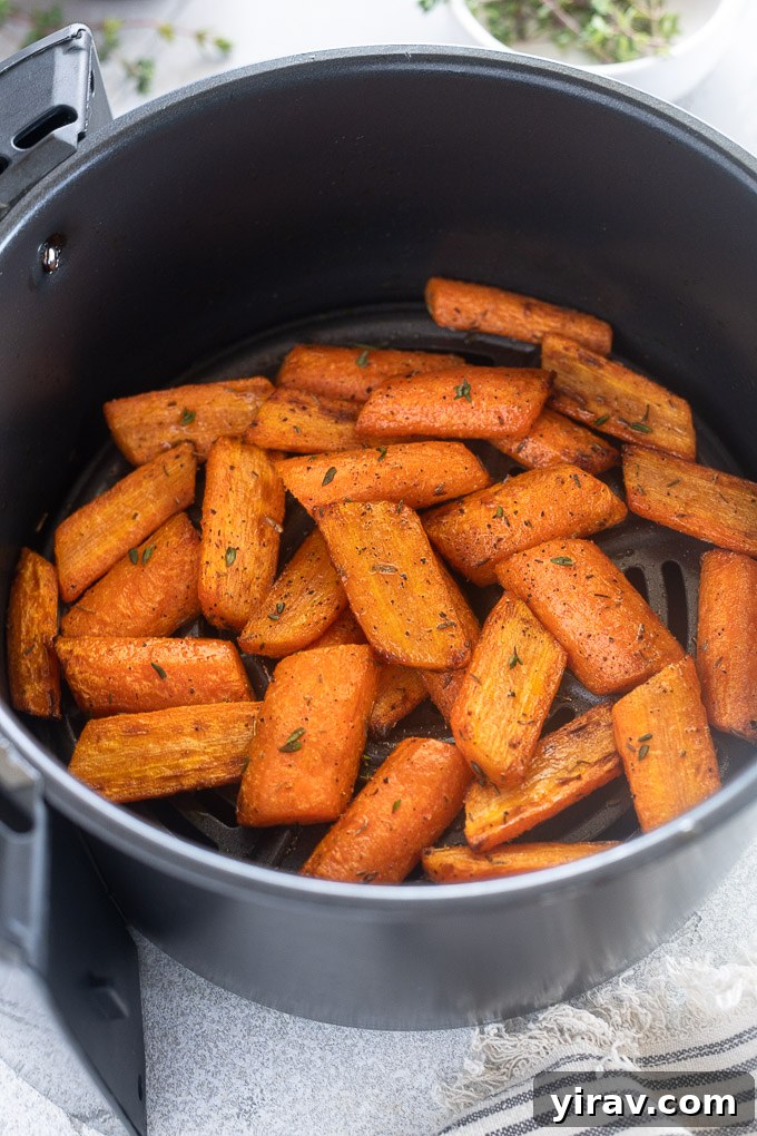 Effortless Air Fryer Roasted Carrots 6 Close-up of perfectly roasted carrots from an air fryer, garnished with fresh thyme.