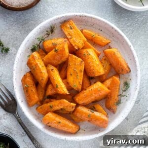 Air fryer carrots on a plate with thyme leaves