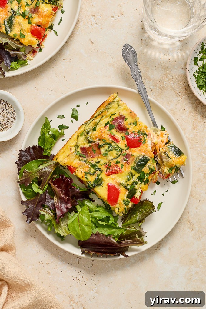 Effortless Bacon and Egg Bake 6 A serving of Bacon and Egg Bake on a white plate, garnished with fresh lettuce for a complete breakfast meal.