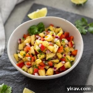 A close-up shot of pineapple salsa in a white bowl, ready to be enjoyed.