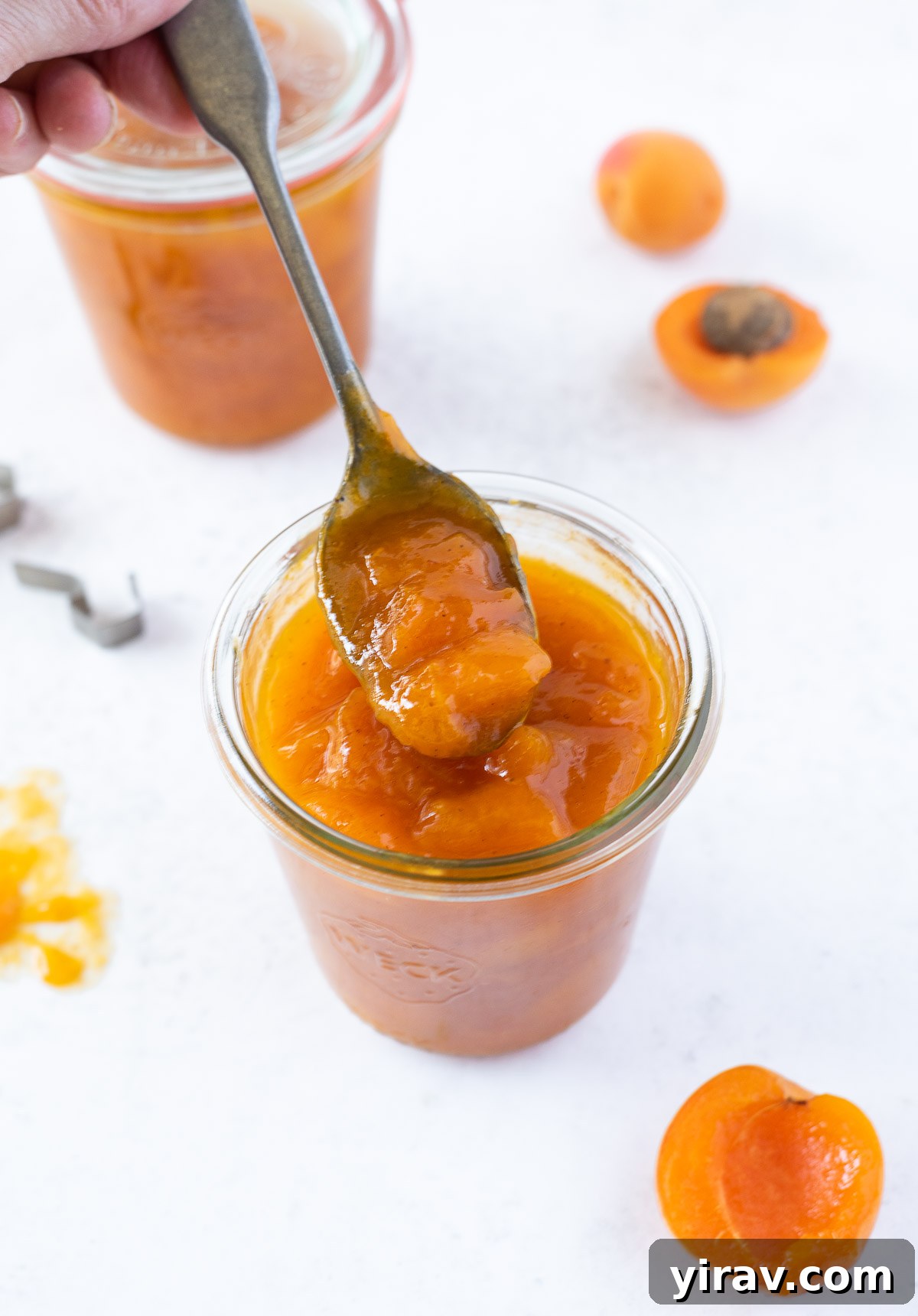 Handcrafted Golden Apricot Jam 7 A close-up shot of a spoon full of homemade apricot jam, highlighting its chunky texture and the rich fruit pieces.
