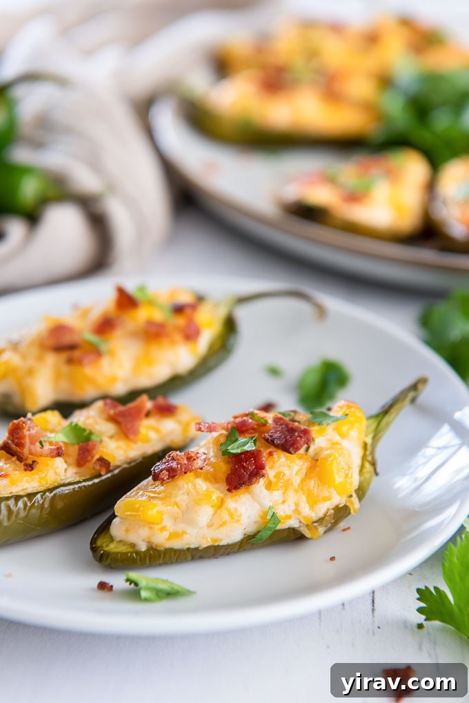 Corn dip stuffed jalapenos with bacon on a serving plate, ready to eat