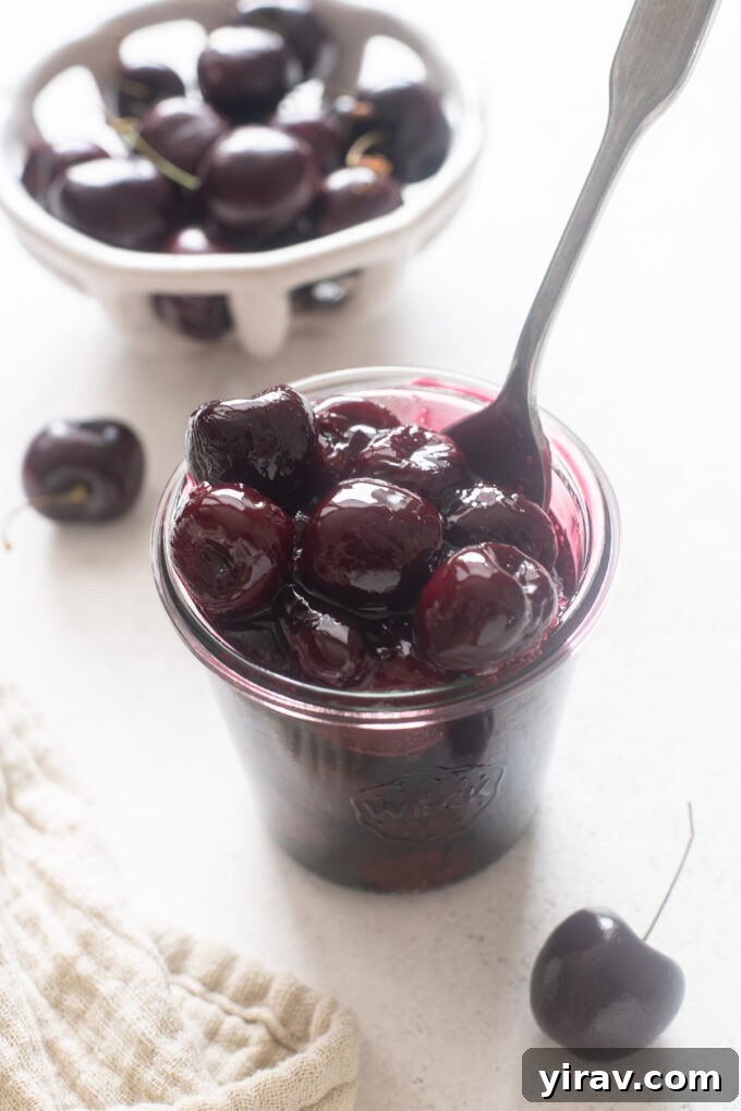 Ruby Red Cherry Bliss 3 Cherry sauce in a jar with spoon digging in.