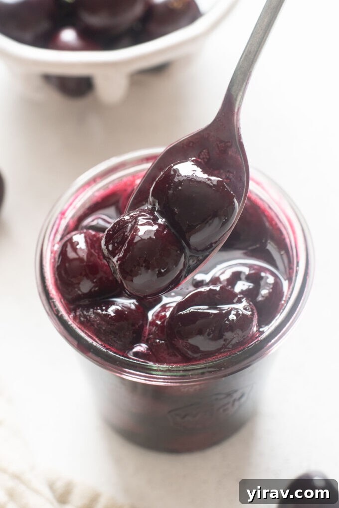 Ruby Red Cherry Bliss 7 Spoonful of cherry compote over a jar.
