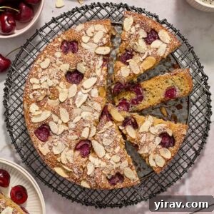 Cherry almond cake sliced on a wire rack.