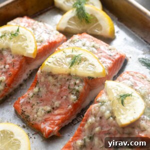 Irresistible Garlic Butter Salmon 8 Garlic butter salmon on a baking sheet with dill and lemon.