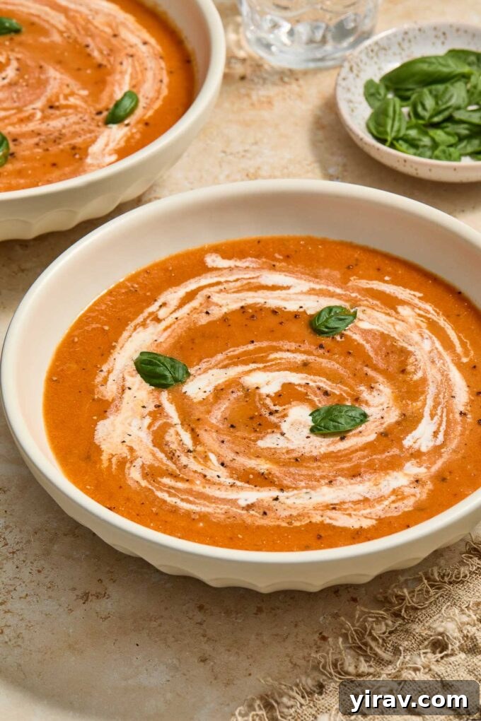 A close-up shot of roasted tomato and basil soup in a rustic bowl, steam gently rising.