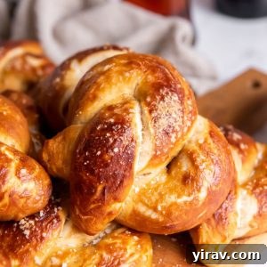 Homemade soft pretzels on a cutting board with a glass of beer