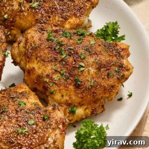 Air fryer chicken thighs on a plate with parsley.