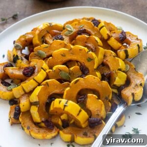 Maple-Kissed Delicata Delight 8 Maple roasted delicata squash on a plate with thyme leaves.
