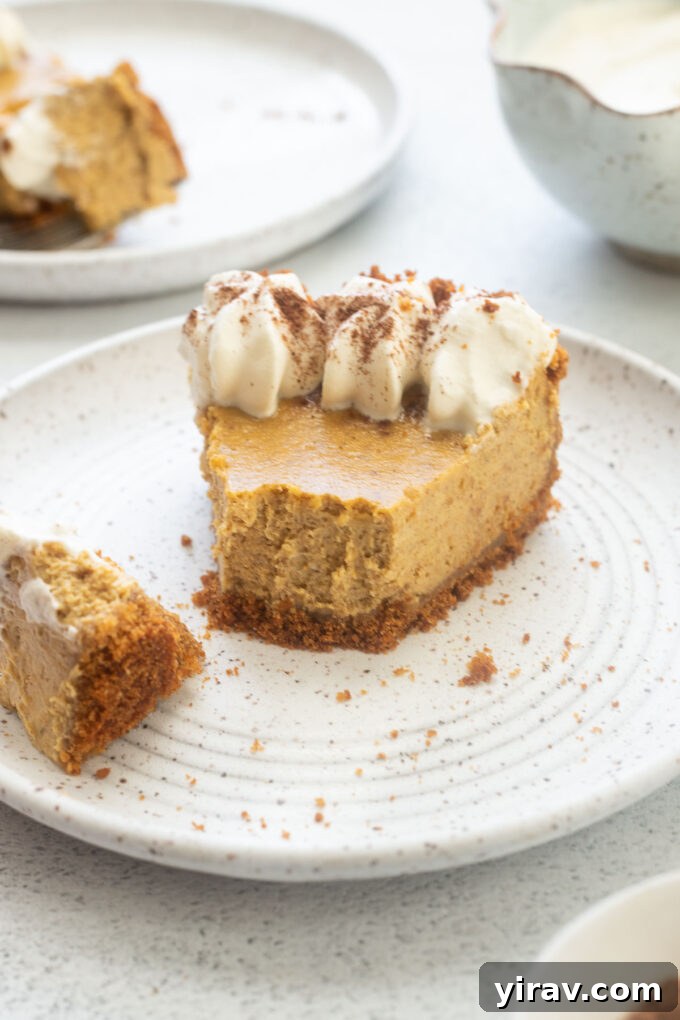 Autumn Spice Pumpkin Cheesecake Delight 8 Pumpkin cheesecake pie on a plate with a bite taken out of it.