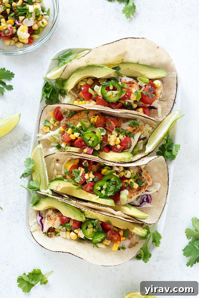 Four perfectly grilled cod fish tacos arranged beautifully on a platter, adorned with colorful salsa and fresh toppings.