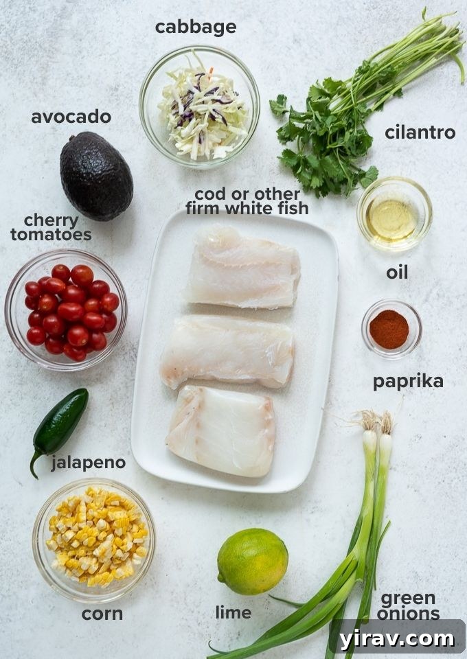 A collection of fresh ingredients laid out, including cod fillets, cherry tomatoes, corn, cilantro, lime, and avocado, ready for grilled fish tacos.