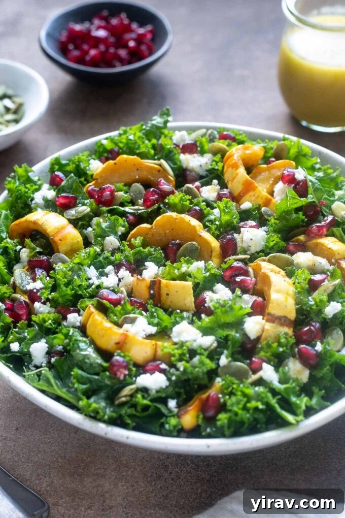Close-up of roasted delicata squash salad with kale and feta cheese, showcasing texture and color.