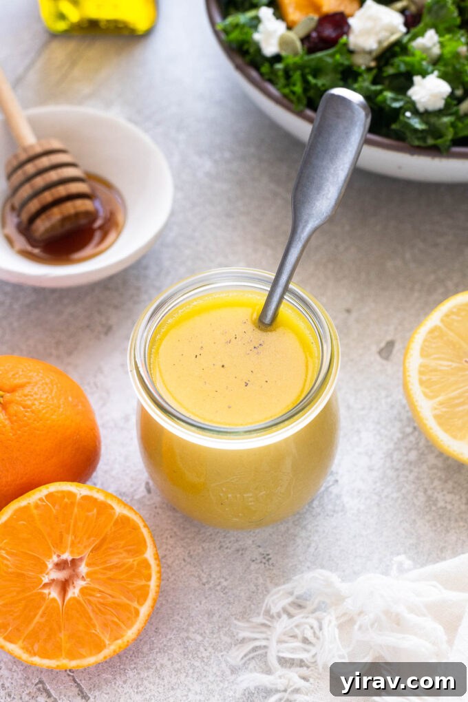 Zesty Citrus Vinaigrette 7 Bright orange salad dressing in a jar with a spoon, highlighting its fresh texture.
